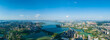 The expansive Jiangxia city unfolds around the serene Tangxun Lake in China, presenting a breathtaking vista of urban development meeting natural beauty under a clear blue sky.