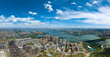 Jiangxia Tangxun Lake landscape shows city buildings reaching the horizon under a bright blue sky.