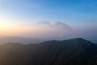 Jiugong Mountain in Xianning City, China features wind turbines on its peaks during a sunset.