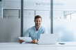 © Stock 4 You - Smiling latin business man salesman working on laptop computer reading financial contract document in office workplace. Young manager businessman specialist doing paperwork analysing on pc. Copy space