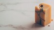 © Softframe - Block of aged cheese on a marble surface, featuring veining and small crumbs around it. The block is yellow with gray veins