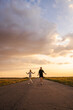 © StockMediaSeller - Two women walking on a country road at sunset, smiling and enjoying the evening outdoors