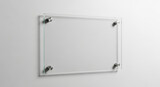 Sleek modern glass sign with brushed metal standoffs mounts on clean white wall