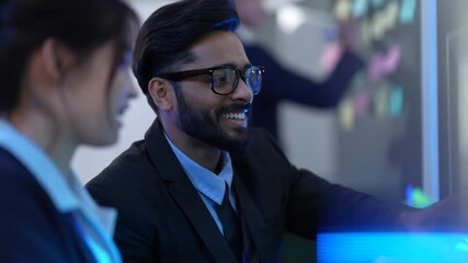A team of AI programmers and data scientists brainstorms in a project meeting. They use sticky notes and a computer to plan the development of new artificial intelligence software.