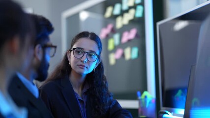 A team of AI programmers and data scientists brainstorms in a project meeting. They use sticky notes and a computer to plan the development of new artificial intelligence software.