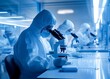 © khoiri - Medical researchers working with microscopes in a sterile laboratory environment