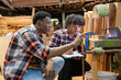 © Washburn - Two carpenters reviewing woodwork design plans