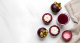 Delicious tropical mangosteen fruit and refreshing juice viewed from above on a clean white marble background with ample copy space