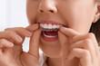 © Pixel-Shot - Young woman putting occlusal splint in mouth at home, closeup