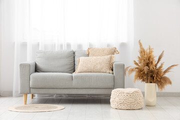 Poster - interior of light living room with grey sofa, pouf and pampas grass in vase