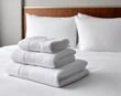 © Sultan - White towels neatly stacked on a hotel bed