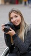 © Kliapko_Photo - Woman in wheelchair taking a photo with a DSLR camera outdoors.