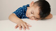 © Ople - Asian little boy sleeping on a white table, accidentally sleeping without thinking much, on a white background, innocent little boy