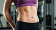 © SULTAN - Close-up of a woman's toned abs in a gym setting.