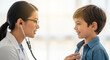 © dubogray1985 - A young, friendly female doctor wearing glasses listens to the chest of a smiling boy with a stethoscope.