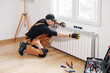 © astrosystem - Central heating mechanic and handyman fixing home radiator, gas crisis and seasonal issues.