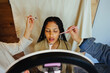 © Jacob Lund - Makeup artist applying cosmetics to a young woman in a studio setting