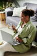 © LIGHTFIELD STUDIOS - Focused African American woman casually working from home in a cozy apartment space