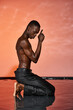 © Bliss - Elegant young man expressing creativity in a serene water setting during sunset