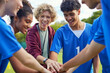 © Rido - Sports team stacking hands before playing football match