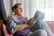 © ADDICTIVE STOCK - Senior woman relaxed and content at home with tablet