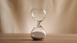 © NadiaA - A simple hourglass on a wooden table with a beige backdrop, symbolizing time flow and minimalistic living. Represents timeless themes in a creative, uncluttered presentation for stylish concepts.