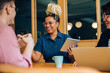 © (JLco) Julia Amaral - Three coworkers having a cheerful discussion at a modern office table