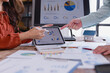 © Tj - Business colleagues using tablet and computer analyzing charts, graphs, and data for real estate investment planning and financial strategy development in office environment