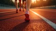 © COK House - Athletes wearing red sneakers run along the stadium track at sunset, useful for articles about sports and motivation to train.