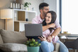 © ivanko80 - Young couple enjoys cozy moment while using a laptop together in a modern living room during daytime
