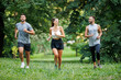 © ivanko80 - Friends jogging together in a green park on a sunny morning, enjoying fitness and outdoor activity