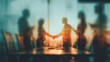 © azwan - Blurred business people shaking hands in a modern office during sunset