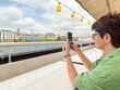 © satura_ - Woman photographing cityscape from ferry deck. Travel, tourism, and lifestyle on Bosphorus in Istanbul.