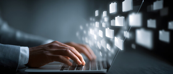 Businessman downloading computer files or installingsoftware on a laptop compuer, cloud storage technoloy, data backup, cyber secuity