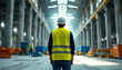 © abu - Man in hard hat and safety vest in vast unfinished industrial space