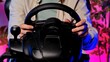 © kinomaster - Person Using Steering Wheel Controller for Gaming Experience