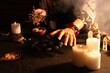 © New Africa - Woman doing ritual with healing stones at dark table, closeup