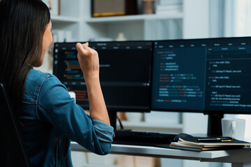 Young Asian IT developer creating raising fist up with successful information on pc with coding program information data application, wearing jeans shirt surround safety analysis screen. Stratagem.
