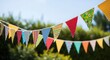 © jerseykamu - Colorful triangular bunting strung against a blurred green backg