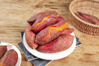 © Nguyen - Fresh Sweet Potatoes with Red Skin and Orange Flesh Displayed on Wooden Table