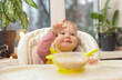 © splitov27 - Cute little baby girl eats on her own at the feeding table