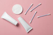 © splitov27 - Cream tubes with cotton pads and ear buds on a pink background