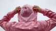 © you are doing great! - Person in a pink polka dot hoodie with hands raised to adjust the hood, viewed from behind against a plain gray sky