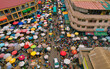 © Amazing Aerial - Accra, Ghana - 23 March 2024: Aerial view of Makola Market's vibrant chaos, where a mosaic of colorful umbrellas and bustling crowds converge, creating a lively tapestry of commerce and community.
