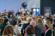 © Anton Gvozdikov - Large audience attending seminar in conference hall. Blurred background shows professional environment.