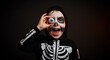 © Onur - Cheerful boy in skeleton costume playing with fake eyeball