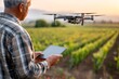 © Lubos Chlubny - Farmer using drone and tablet for smart agriculture in vineyard at sunset