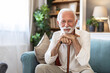 © Jelena Stanojkovic - Depression, nostalgia and a senior man with a cane on a sofa in the living room of his retirement home alone. Memory, thinking and an elderly person with a walking stick in a house feeling sad