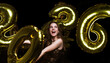 © ty - Happy gorgeous girl in stylish sexy party dress holding gold 2026 balloons, having fun at New Year's Eve Party.