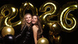 © ty - Happy gorgeous girls in stylish sexy party dresses holding gold 2026 balloons, having fun at New Year's Eve Party.